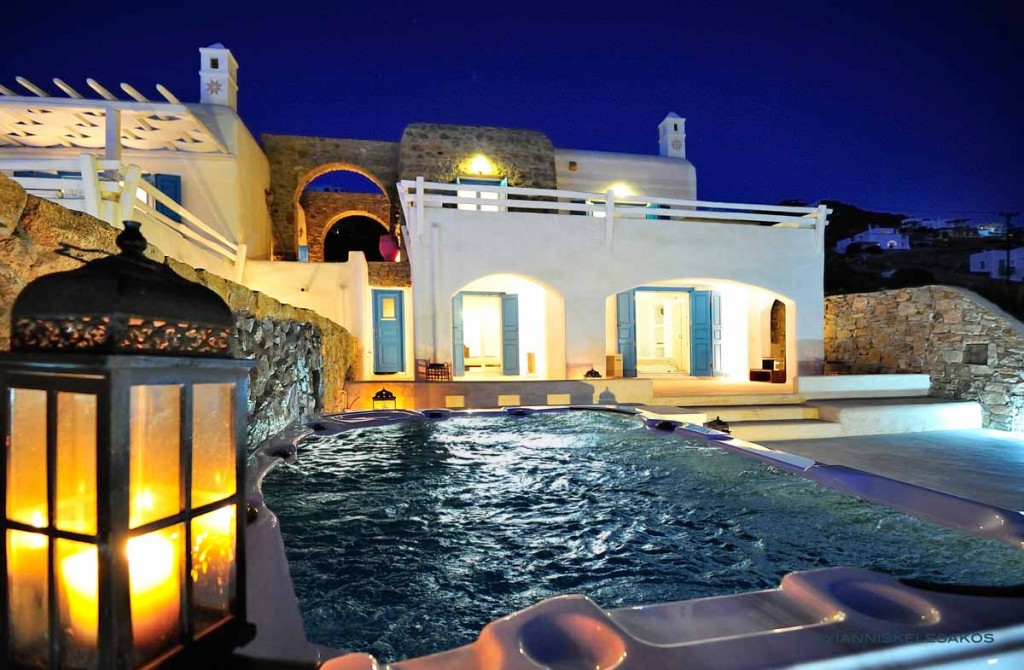 Pool and terrace lit at night at Villa Hestia in Choulakia, Mykonos