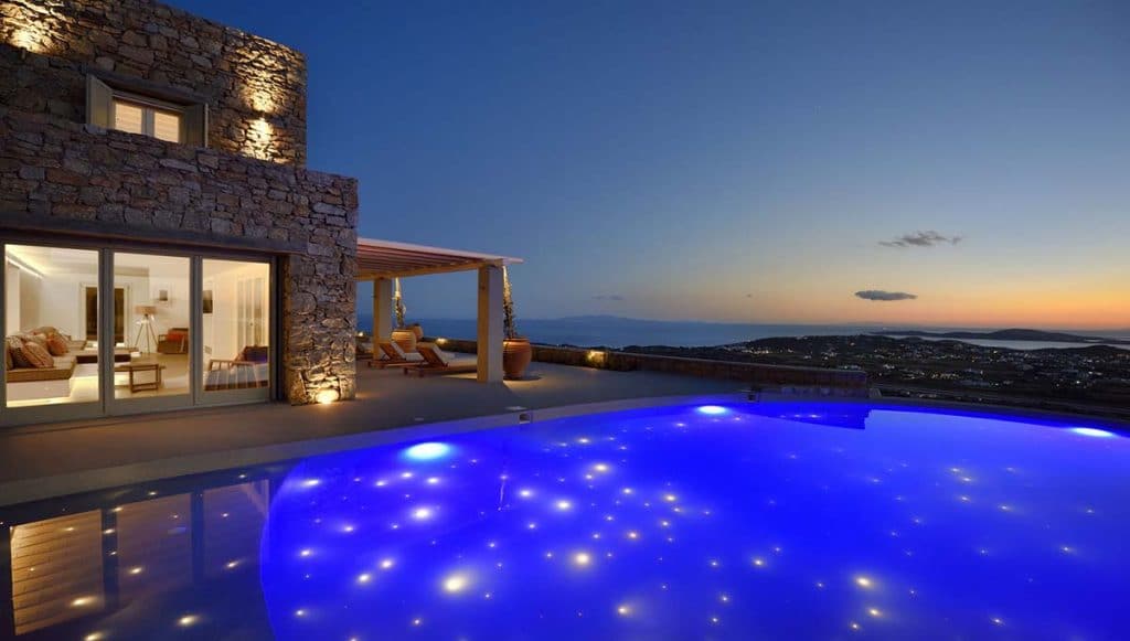 Villa and fibre-optic lit pool at dusk at Villa Sunstone in Kounoupas, Mykonos