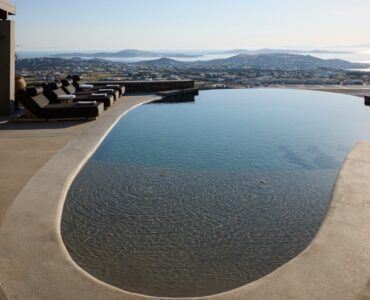 Infinity pool and sun loungers at sunset at Villa Sunstone, Kounoupas, Mykonos
