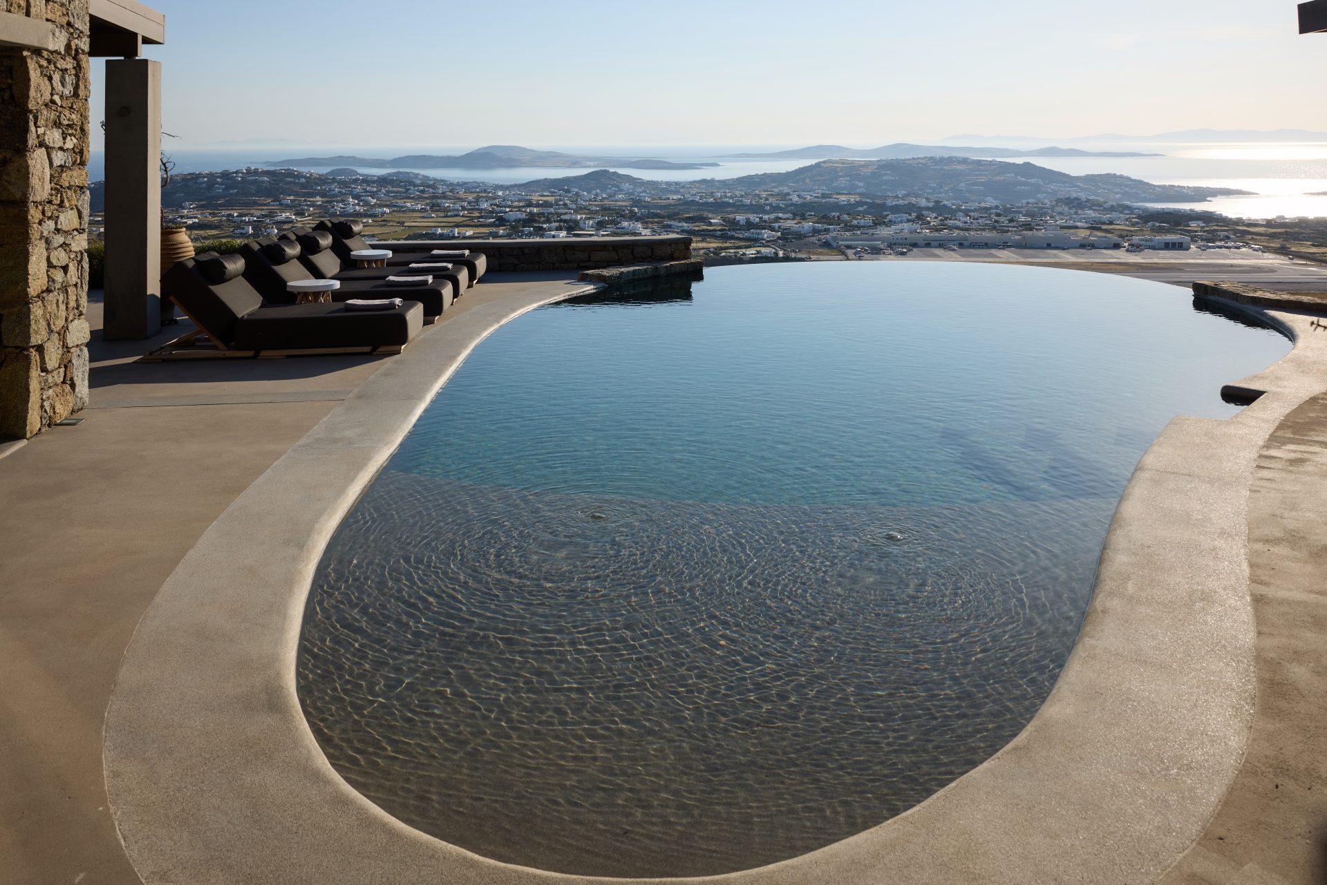 Infinity pool and sun loungers at sunset at Villa Sunstone, Kounoupas, Mykonos