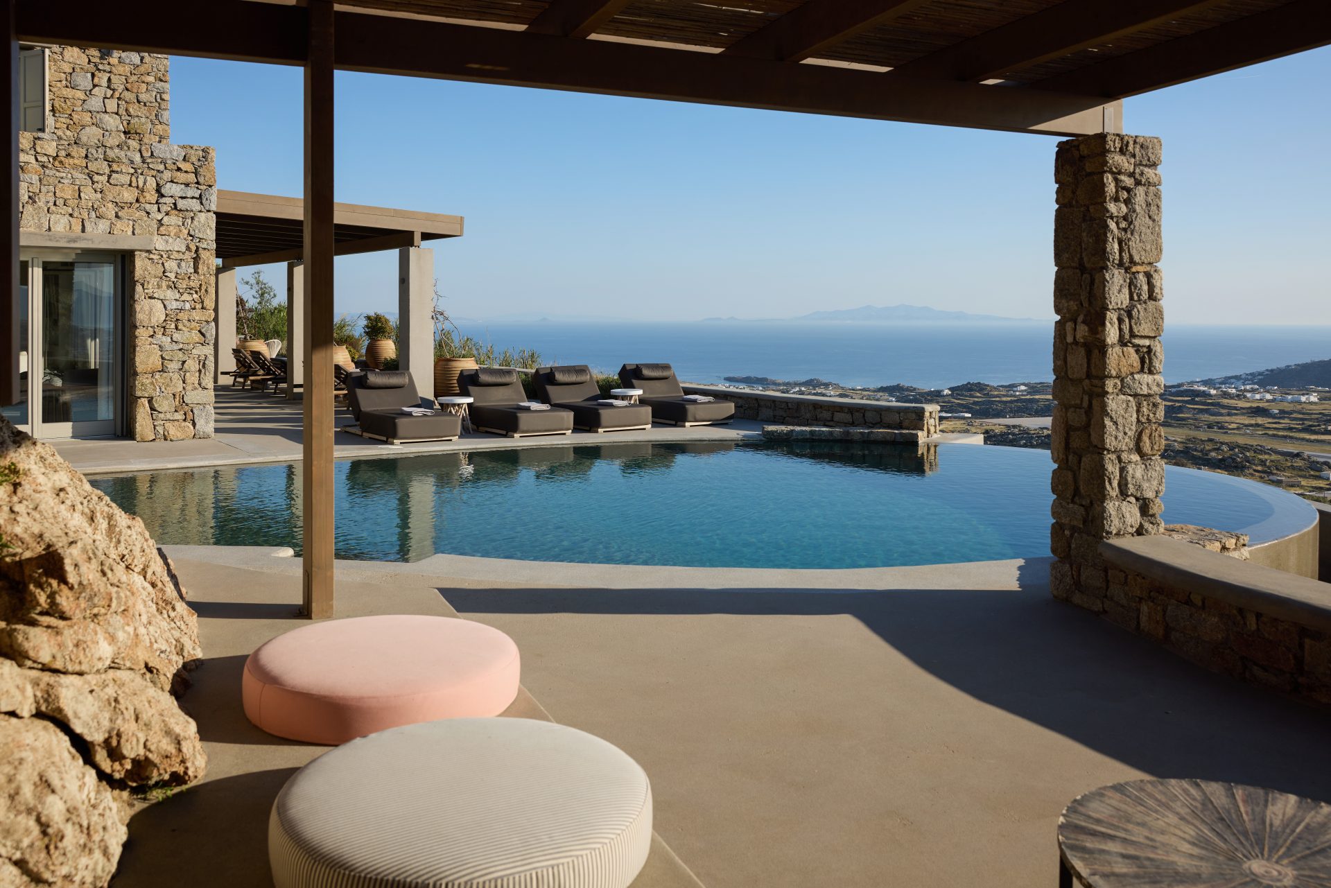 Shaded pool lounge with sea view at Villa Sunstone, Kounoupas, Mykonos