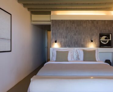 Master bedroom with stone feature wall at Villa Amethyst, Kounoupas, Mykonos