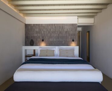 Master bedroom with stone feature wall at Villa Ammolite, Kounoupas, Mykonos