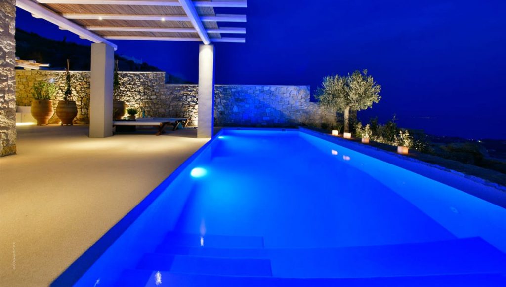 Lit pool and pergola at night at Villa Amethyst in Kounoupas, Mykonos