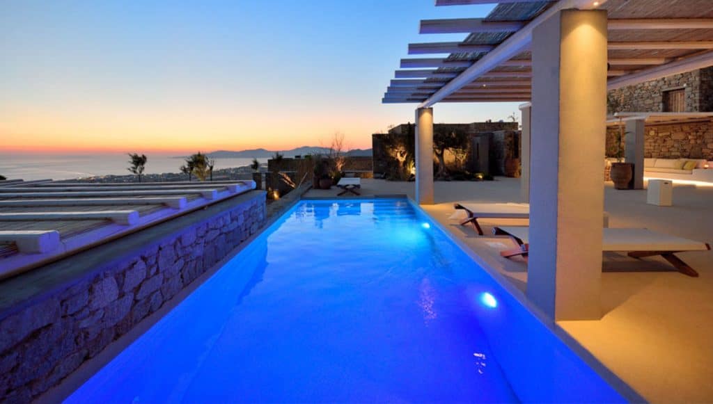 Lit pool at dusk with sea view at Villa Ammolite in Kounoupas, Mykonos