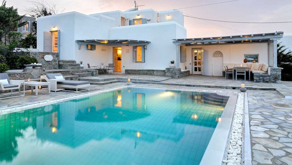 Pool and white villa at dusk at Villa Nellie in Kalafatis, Mykonos