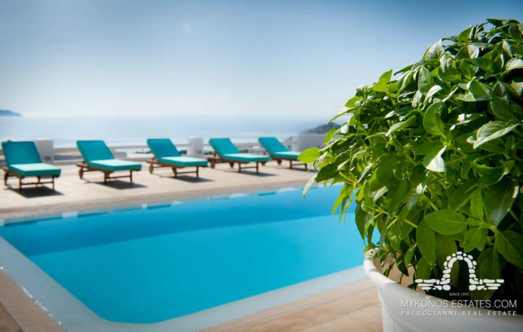 Pool with turquoise loungers and plants at Anatolia in Kalafatis, Mykonos