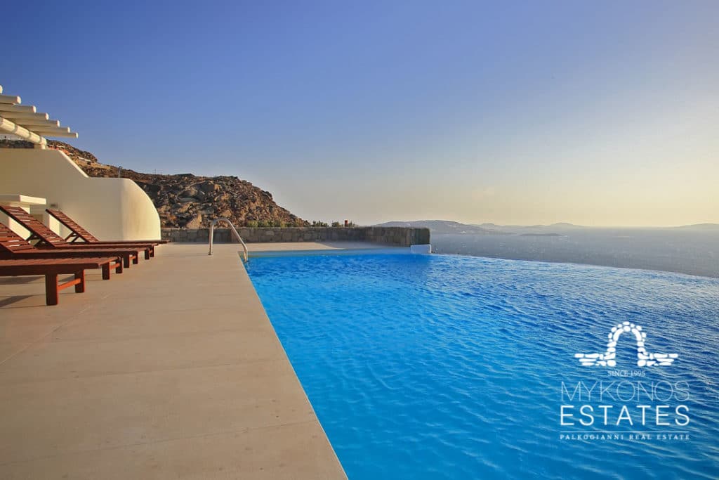 Infinity pool stretching to the sea at sunset at Casa Del Mar, for sale in Tourlos, Mykonos