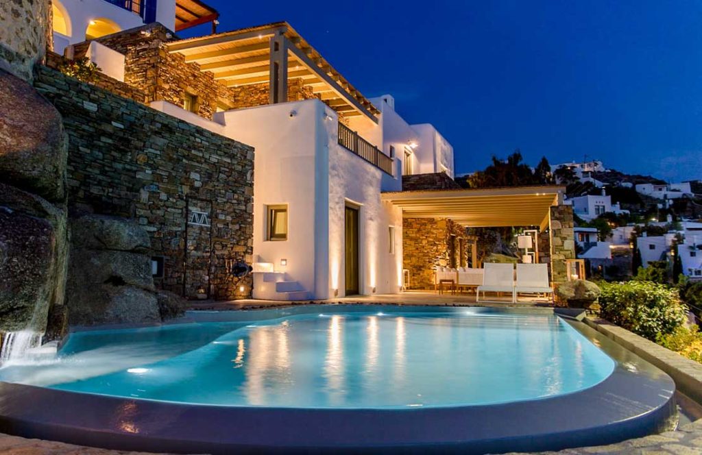 Lit pool and terraces at dusk at Villa Serona in Mykonos Town