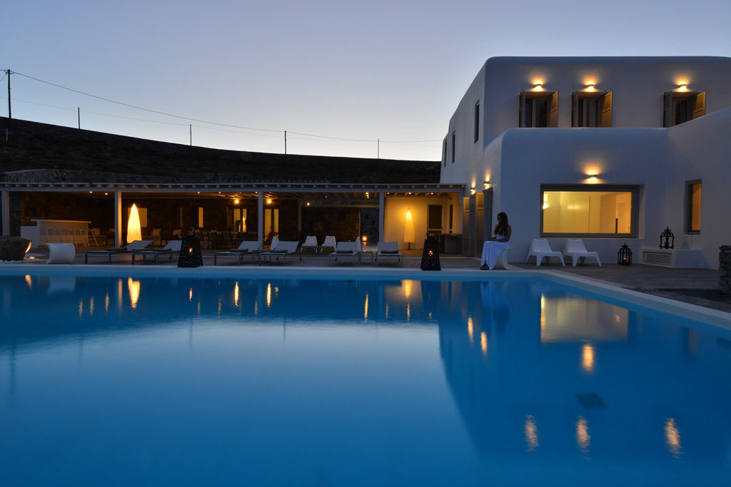 Pool and villa lit at dusk at Grace Estate, for sale in Aleomandra, Mykonos