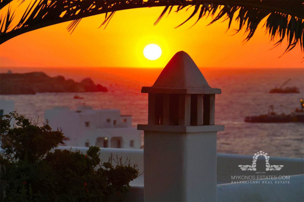Sunset over the sea and a white chimney at Villa Ammia, for sale in Mykonos Town