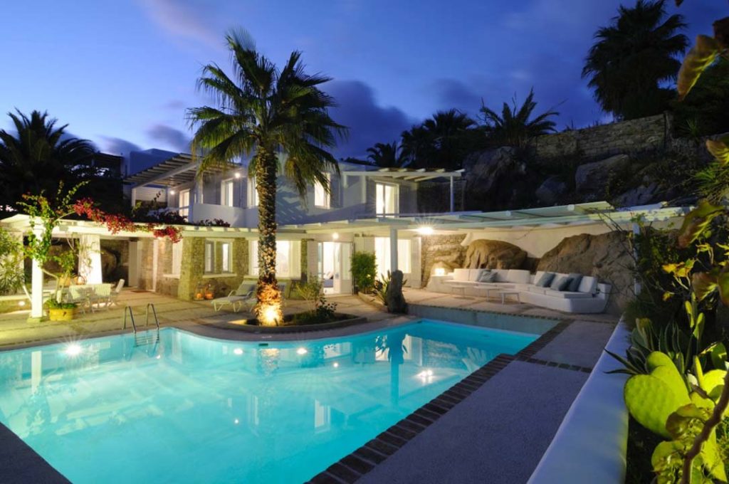 Pool and palms at dusk at Villa Neon in Aleomandra, Mykonos