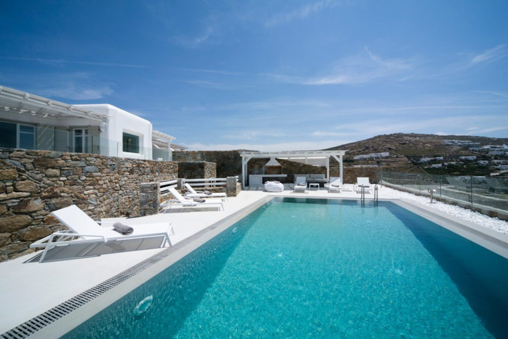 Infinity pool with white loungers at Villa Elia, for sale in Elia, Mykonos