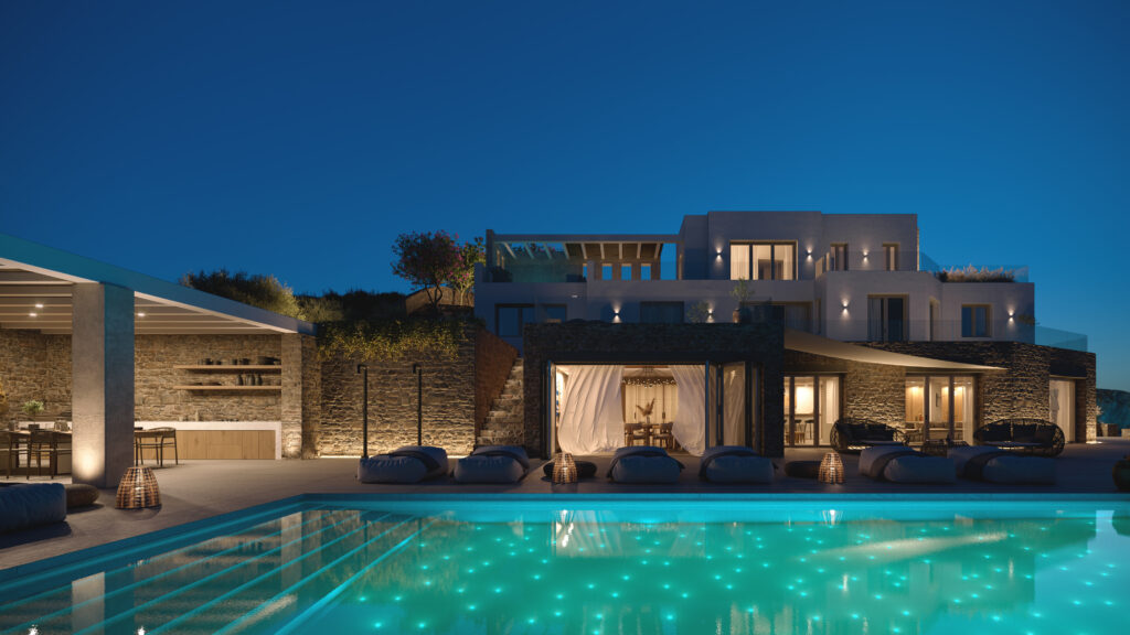 The Aerie villa in Agia Sofia, Mykonos, at dusk with the lit infinity pool in front of the stone and white main house
