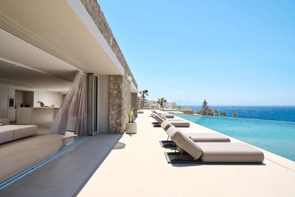 Sun loungers along the infinity pool with Aegean Sea view at Blue Diamond Estate, Kalo Livadi