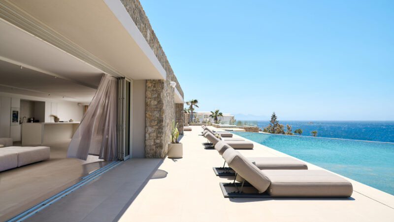 Sun loungers along the infinity pool with Aegean Sea view at Blue Diamond Estate, Kalo Livadi