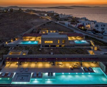 Aerial view of the villa with pools lit at dusk at Aether Private Retreat - Grand Villa, Aleomandra, Mykonos