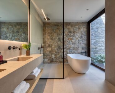 En-suite bathroom with freestanding bathtub and stone walls at Aether Private Retreat - Grand Villa, Aleomandra, Mykonos