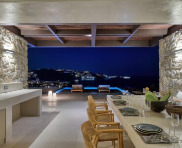 Outdoor dining area at dusk overlooking the sea at Aether Private Retreat - Grand Villa, Aleomandra, Mykonos