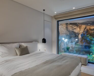 Bedroom with picture window onto the planted garden at Aether Private Retreat - Grand Villa, Aleomandra, Mykonos