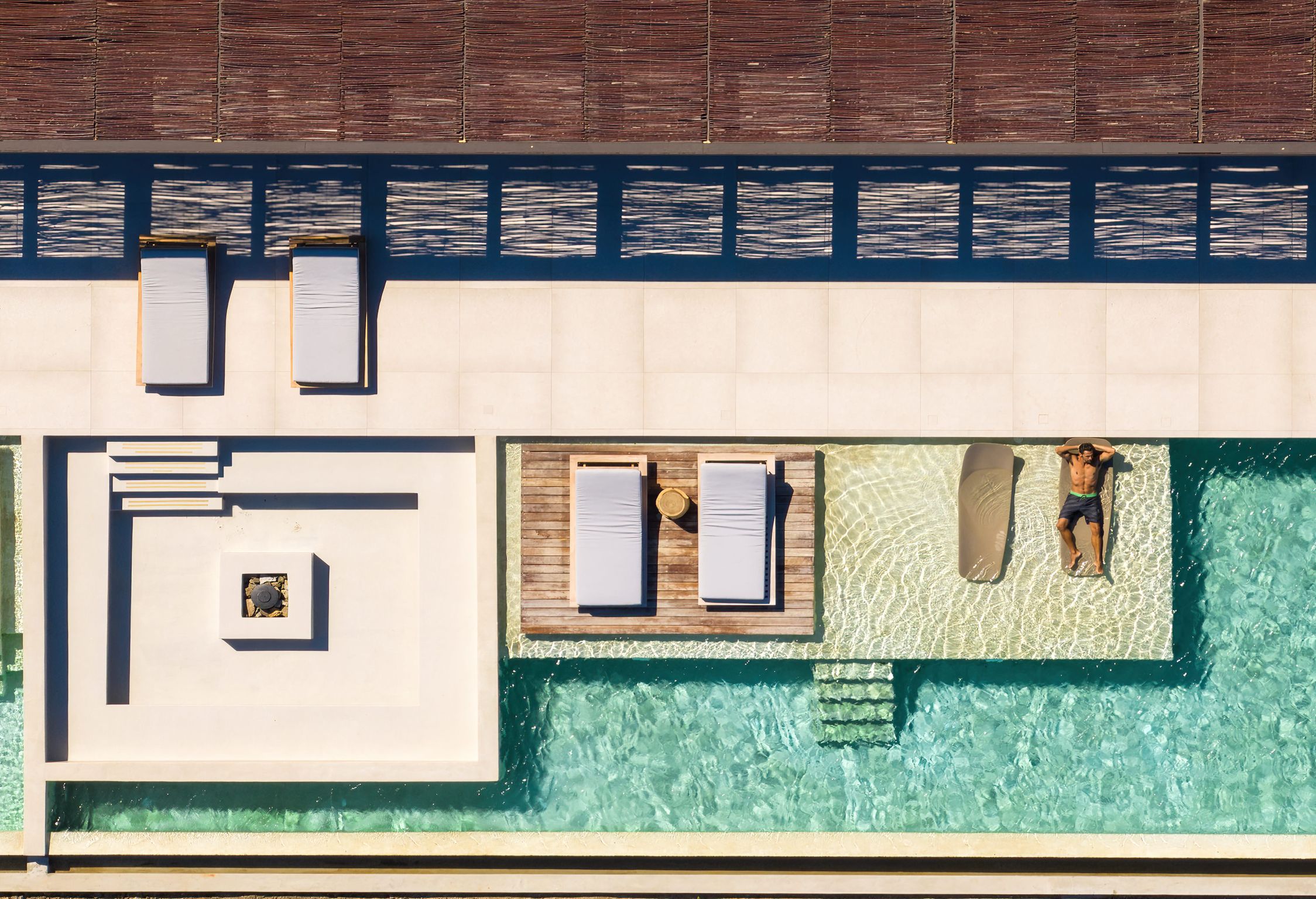 Top-down aerial view of the pool deck and sun loungers at Aether Private Retreat - Ground Floor, Aleomandra, Mykonos
