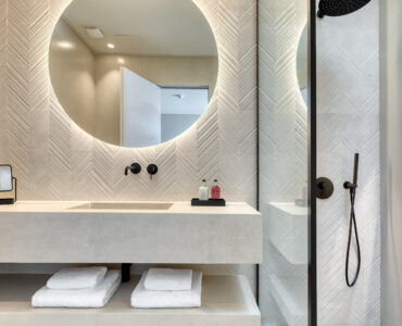 En-suite bathroom with round mirror and stone-finish vanity at Aether Private Retreat - Ground Floor, Aleomandra, Mykonos