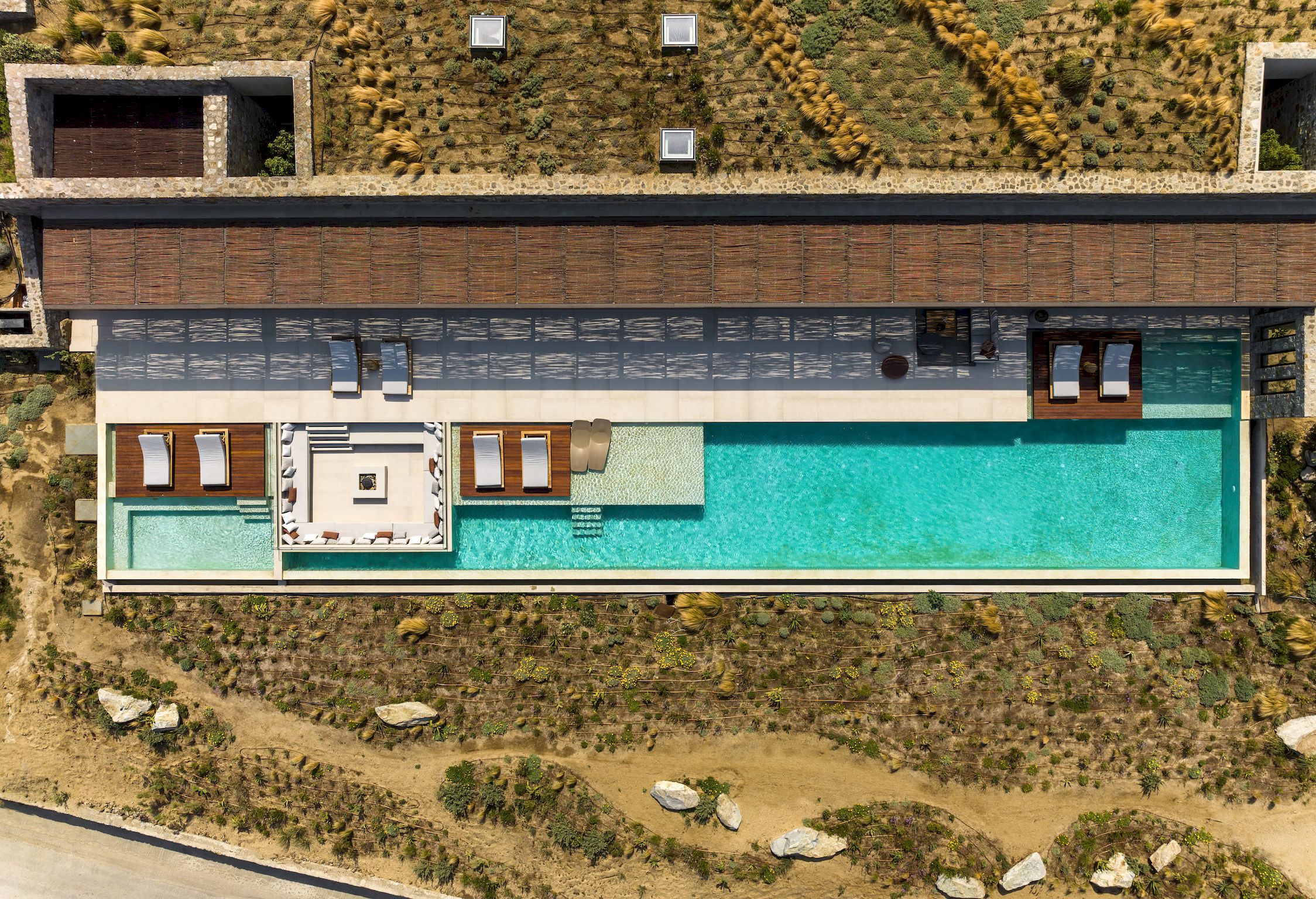 Top-down aerial view of the pool deck and sun loungers at Aether Private Retreat - Ground Floor, Aleomandra, Mykonos