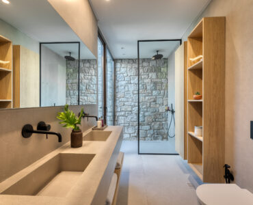 En-suite bathroom with round mirror and stone-finish vanity at Aether Private Retreat - Ground Floor, Aleomandra, Mykonos