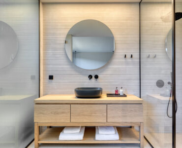 En-suite bathroom with round mirror and stone-finish vanity at Aether Private Retreat - Ground Floor, Aleomandra, Mykonos