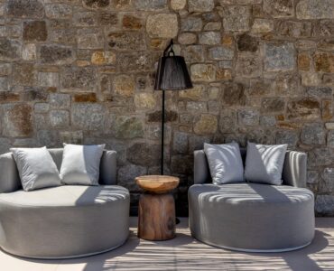 Round lounge chairs against a natural stone wall at Aether Private Retreat - Ground Floor, Aleomandra, Mykonos
