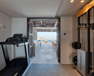 Indoor gym with treadmill and open view towards the sea at Aether Private Retreat - Ground Floor, Aleomandra, Mykonos