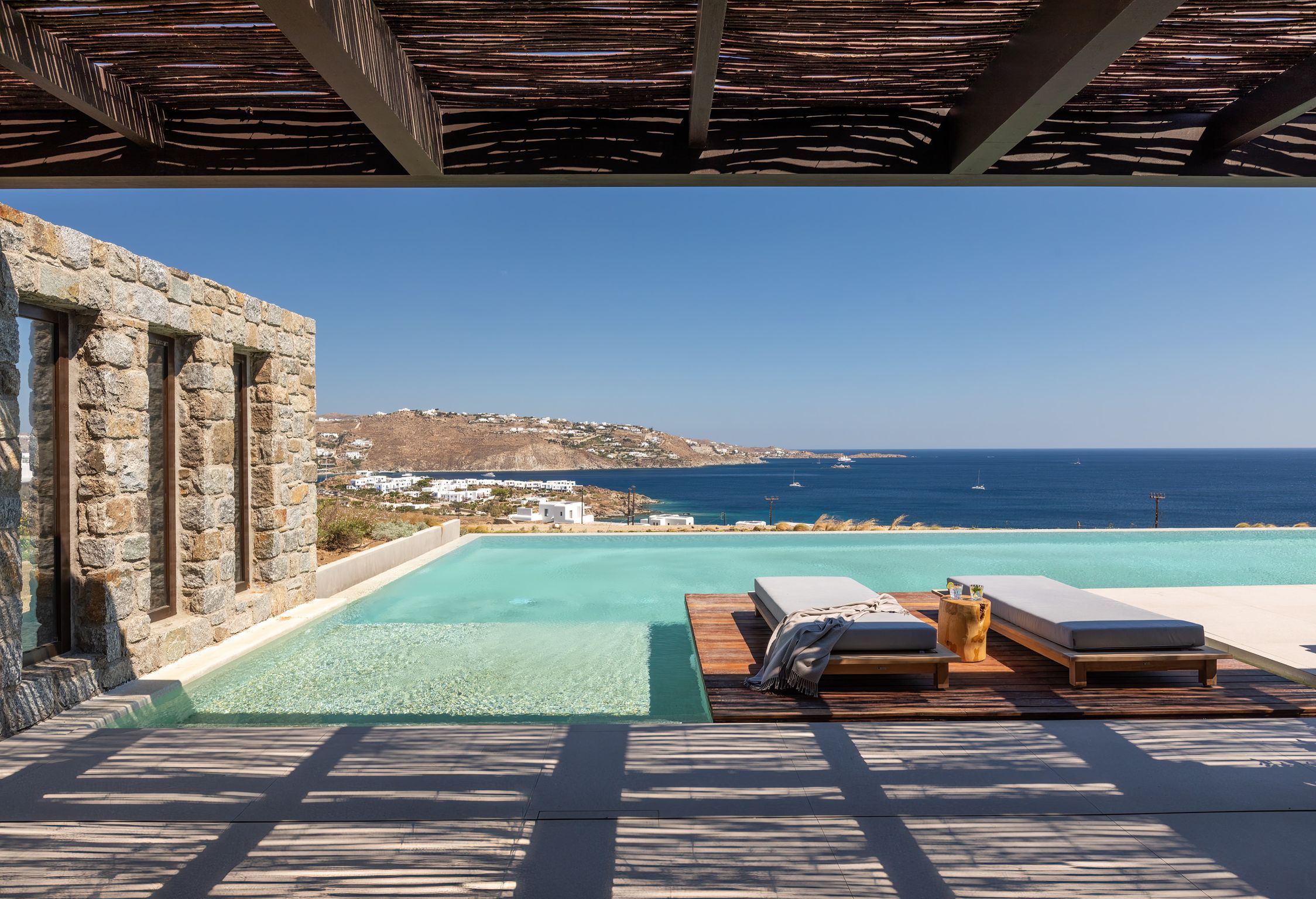 Pool terrace with shaded lounge area and sea views at Aether Private Retreat - Ground Floor, Aleomandra, Mykonos