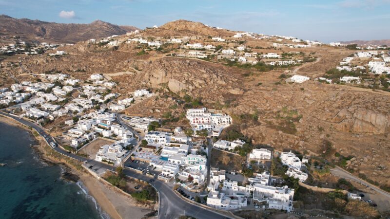 Aerial drone view of seafront house at Agia Anna Gyalos beach Mykonos Town for sale