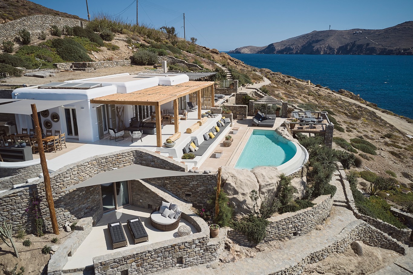Aerial view of the sea front villa and infinity pool above Ftelia beach at Bali Sea Front Villa in Ftelia, Mykonos
