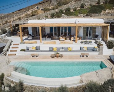 Aerial view of the sea front villa and infinity pool above Ftelia beach at Bali Sea Front Villa in Ftelia, Mykonos