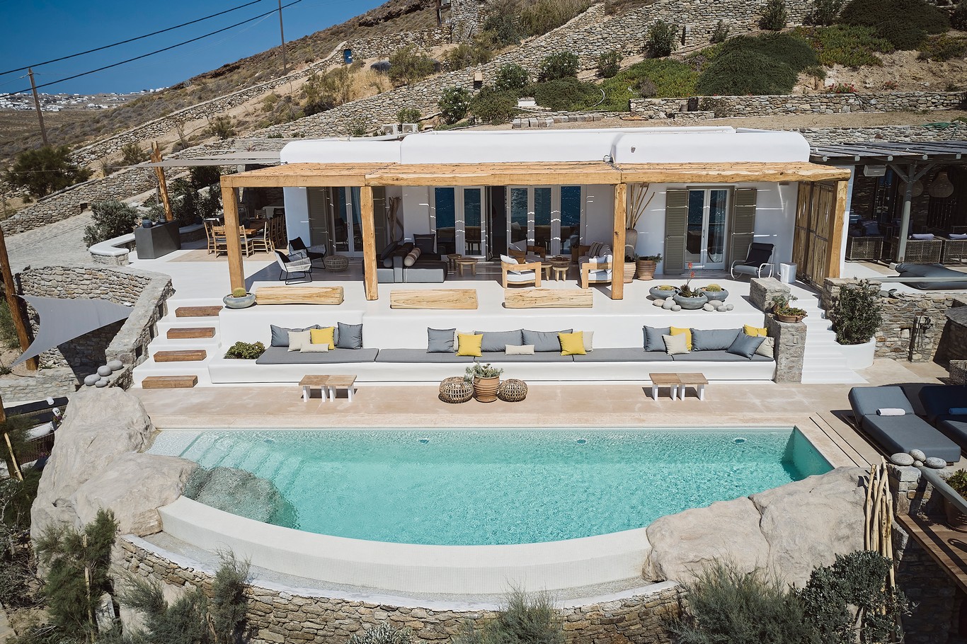 Aerial view of the sea front villa and infinity pool above Ftelia beach at Bali Sea Front Villa in Ftelia, Mykonos