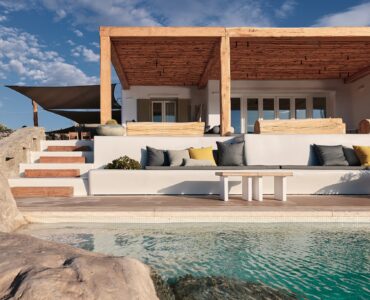 Infinity pool with sun loungers and views over Ftelia bay at Bali Sea Front Villa in Ftelia, Mykonos
