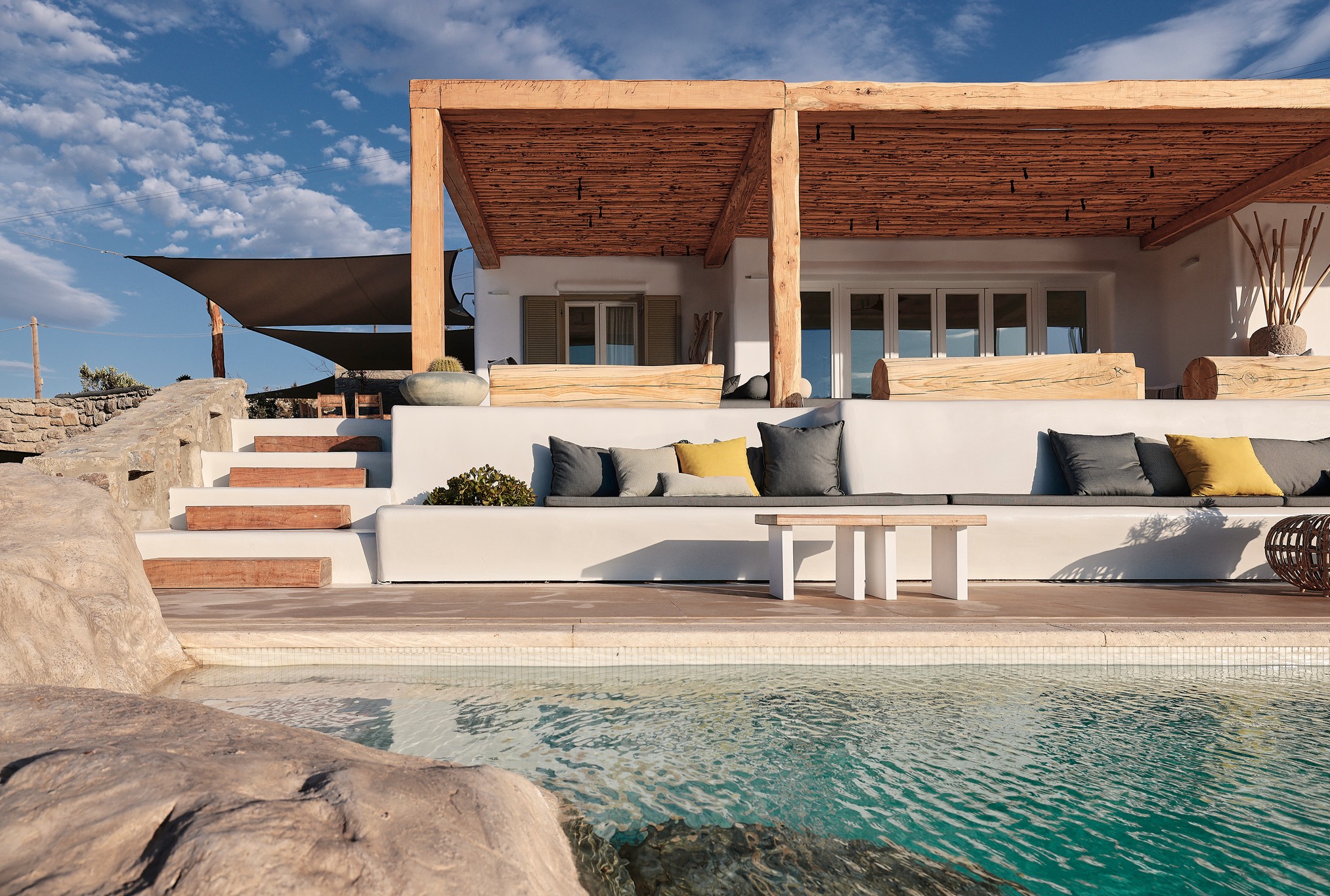 Infinity pool with sun loungers and views over Ftelia bay at Bali Sea Front Villa in Ftelia, Mykonos