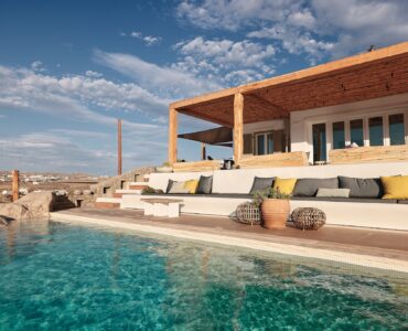 Infinity pool with sun loungers and views over Ftelia bay (view 2) at Bali Sea Front Villa in Ftelia, Mykonos
