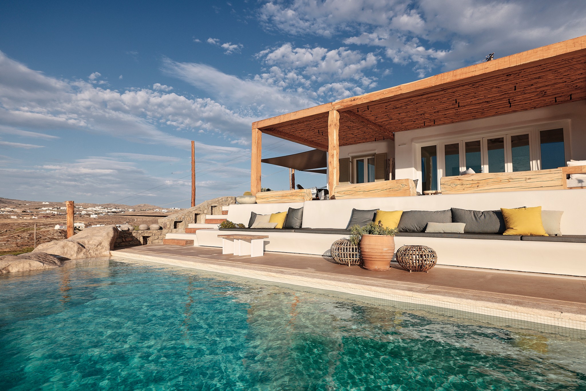 Infinity pool with sun loungers and views over Ftelia bay (view 2) at Bali Sea Front Villa in Ftelia, Mykonos