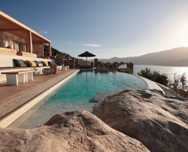 Infinity pool with sun loungers and views over Ftelia bay (view 3) at Bali Sea Front Villa in Ftelia, Mykonos
