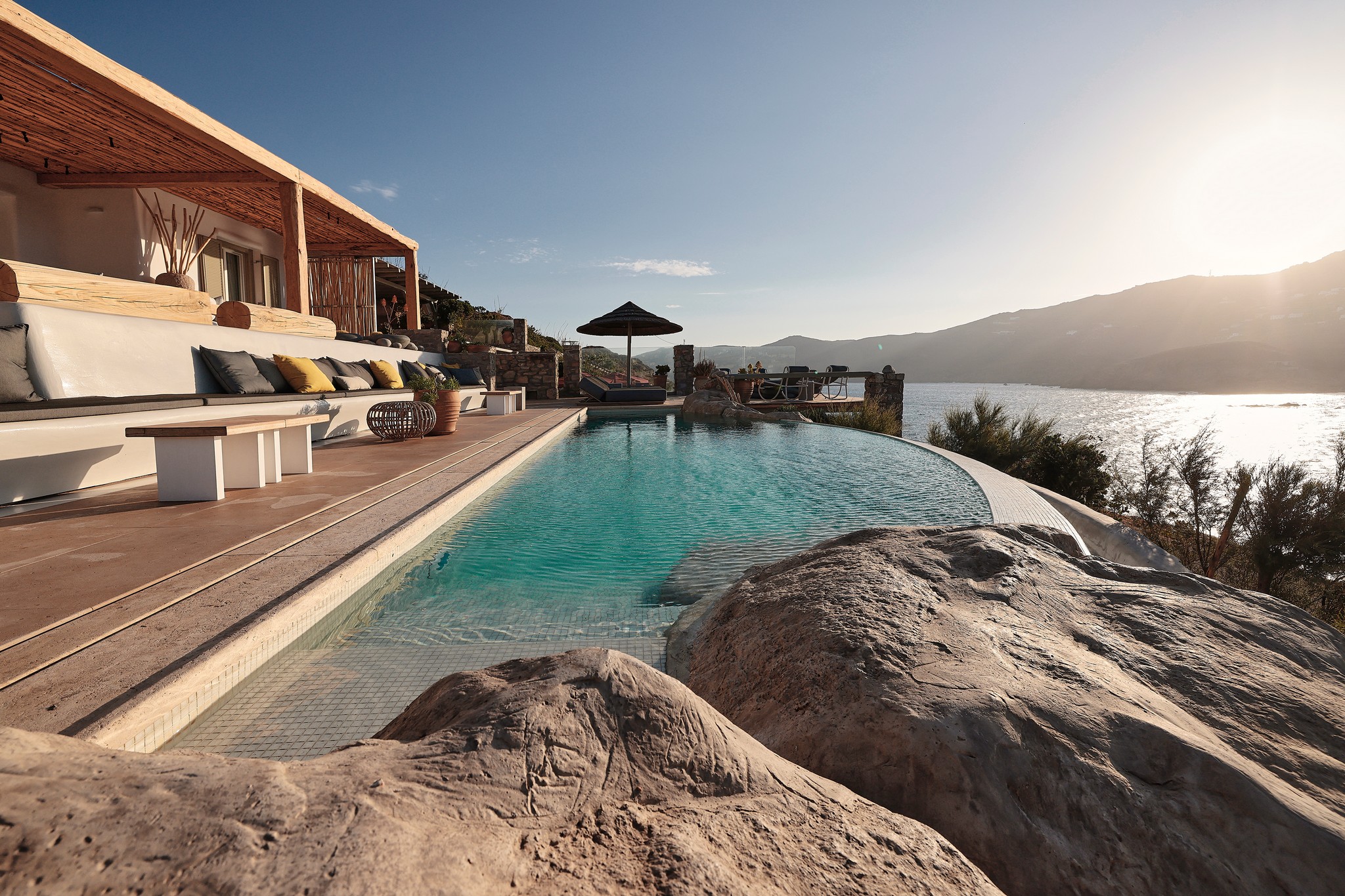 Infinity pool with sun loungers and views over Ftelia bay (view 3) at Bali Sea Front Villa in Ftelia, Mykonos