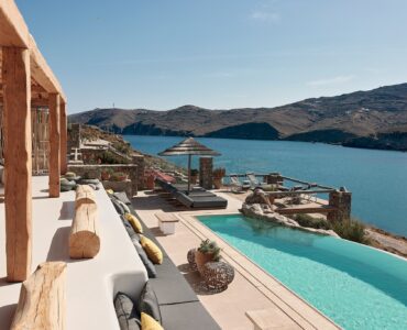 Infinity pool with sun loungers and views over Ftelia bay (view 4) at Bali Sea Front Villa in Ftelia, Mykonos