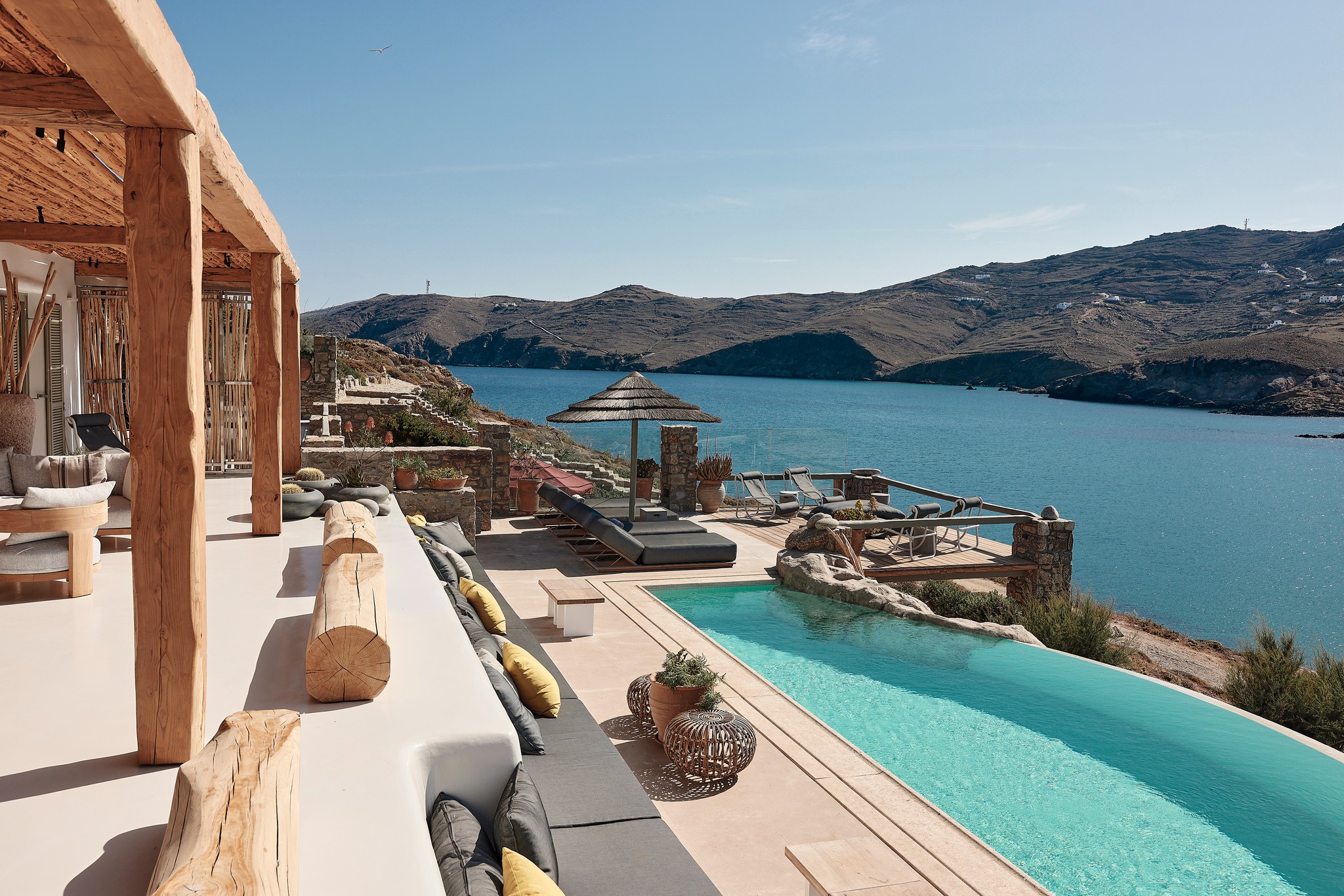 Infinity pool with sun loungers and views over Ftelia bay (view 4) at Bali Sea Front Villa in Ftelia, Mykonos