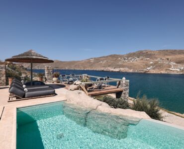 Infinity pool with sun loungers and views over Ftelia bay (view 5) at Bali Sea Front Villa in Ftelia, Mykonos
