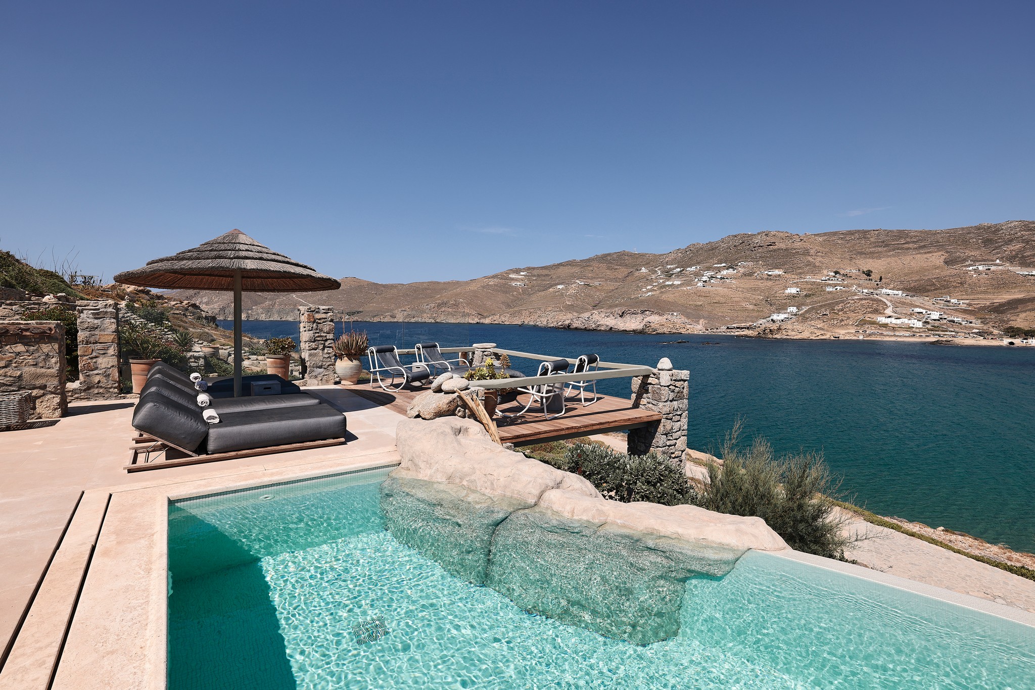 Infinity pool with sun loungers and views over Ftelia bay (view 5) at Bali Sea Front Villa in Ftelia, Mykonos
