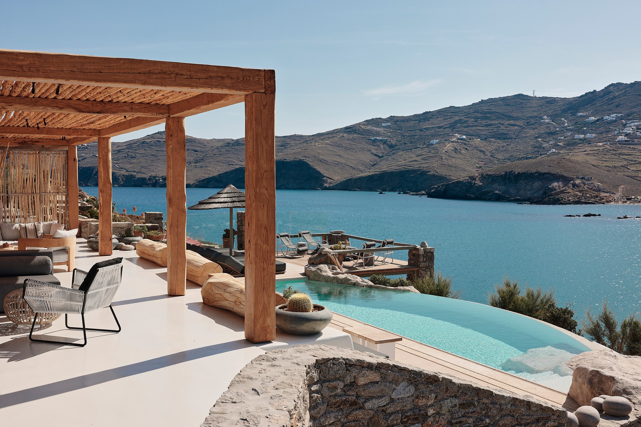 Infinity pool with sun loungers and views over Ftelia bay (view 6) at Bali Sea Front Villa in Ftelia, Mykonos