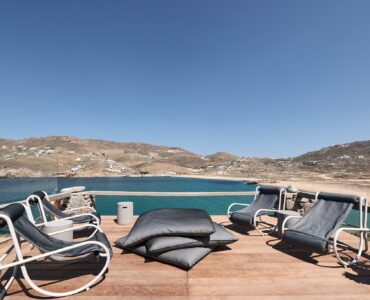 Infinity pool with sun loungers and views over Ftelia bay (view 8) at Bali Sea Front Villa in Ftelia, Mykonos