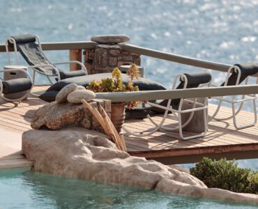 Infinity pool with sun loungers and views over Ftelia bay (view 9) at Bali Sea Front Villa in Ftelia, Mykonos