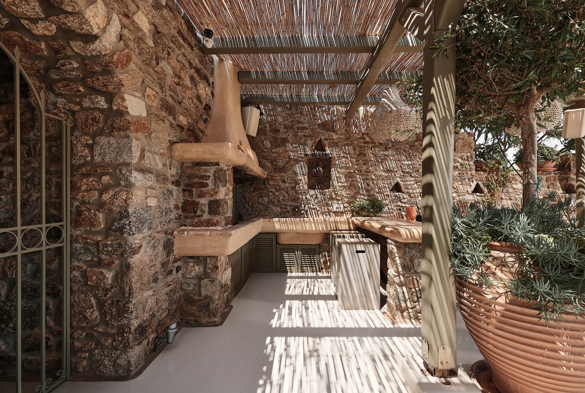 Patio with built-in BBQ and outdoor seating at Bali Sea Front Villa in Ftelia, Mykonos